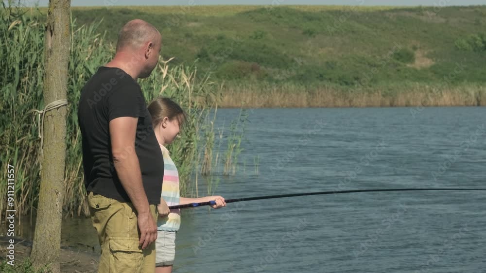 Father and daughter fishing with rod on river. Family spending time together, having fun. Fathers day concept Father and daughter fishing with rod on river. Family spending time together, having fun. Fathers day concept