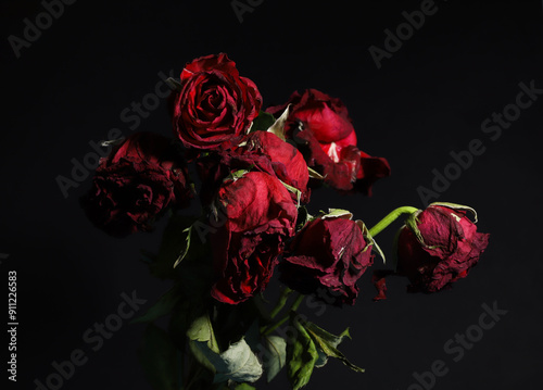 Fototapeta Naklejka Na Ścianę i Meble -  wilted red roses on a black background