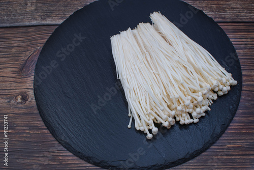 Enokitake mushrooms on dark background, copy space photo