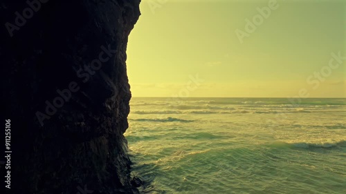 Droneflight  through natural bridge into the sunset on Praia da Adraga Portugal. photo