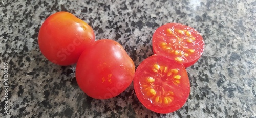 Beautiful red tomato on a stone table. Cherry tomato variety