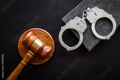 Police metal handcuffs with criminal code book and judges gavel. Law and justice concept photo