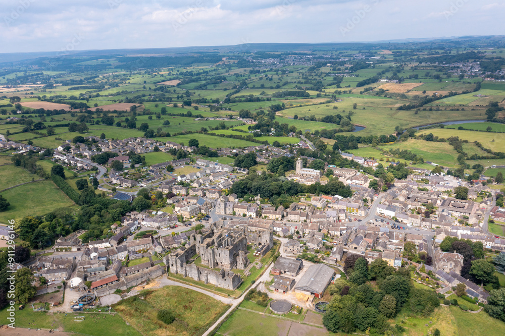 Obraz premium Aerial drone photo of the beautiful town of Middleham in Leyburn in North Yorkshire in the UK showing the British countryside town and the historic Middleham Castle on a sunny day in the summer time