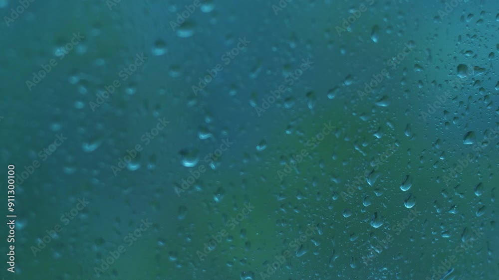 raindrops on window glass in heavy rain outside, bad weather and strong wind with rain outside the window on a summer day, selective focus raindrops on window glass in heavy rain outside, bad weather and strong wind with rain outside the window on a summer day, selective focus