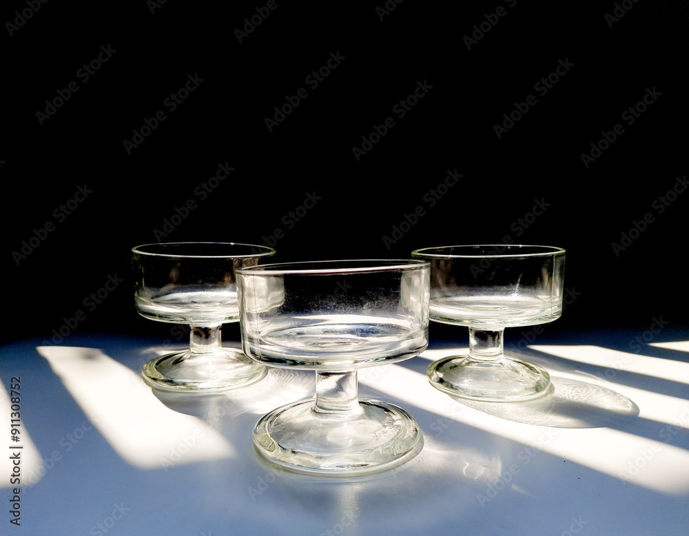 Aesthetic of transparent glasses for drink events with lines of sun shadow and glare on isolated background Aesthetic of transparent glasses for drink events with lines of sun shadow and glare on isolated background