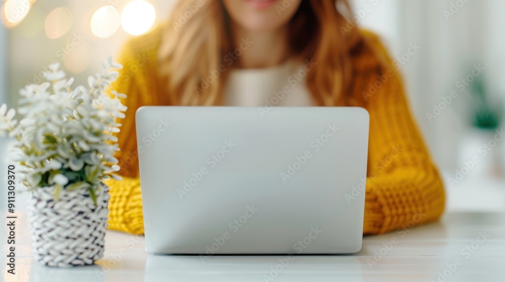 A young professional sitting at a desk, applying for a job on a laptop