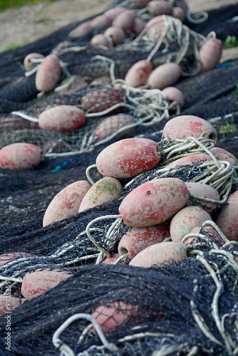 Obraz na płótnie sieć rybacka z pływakami na brzegu, suszące sie na brzegu sieci rybackie z pływakami, fishing net on the shore, fishing net drying, Fishing net in the harbor, nets and floats are dried on the shore. w salonie