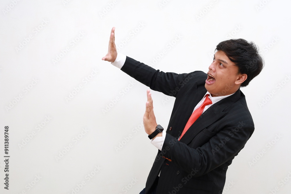Portrait of frightened shocked businessman in suit raising hands in fear, looking horrified and panicking, hiding from phobia. isolated on white background Portrait of frightened shocked businessman in suit raising hands in fear, looking horrified and panicking, hiding from phobia. isolated on white background