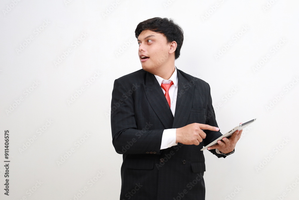 Young asian businessman standing using tablet computer while looking advertising sideways isolated on white background