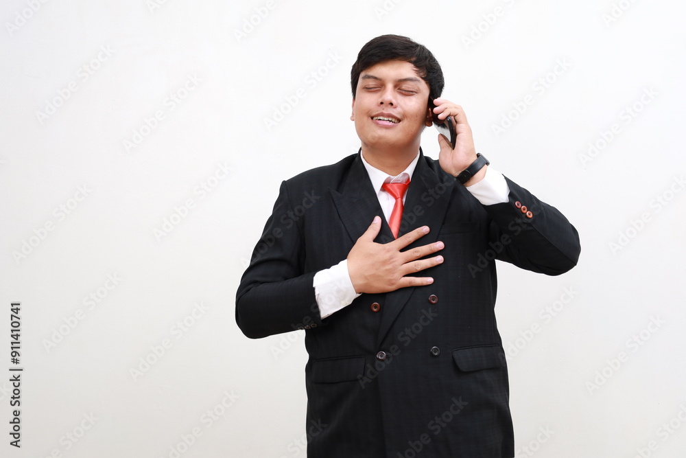 Relieved and happy Indonesian businessman employees standing while talking on the phone. Isolated on white Relieved and happy Indonesian businessman employees standing while talking on the phone. Isolated on white