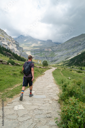 Hiker walking on a stone path in a mountainous landscape of Monte Perdido, Spain