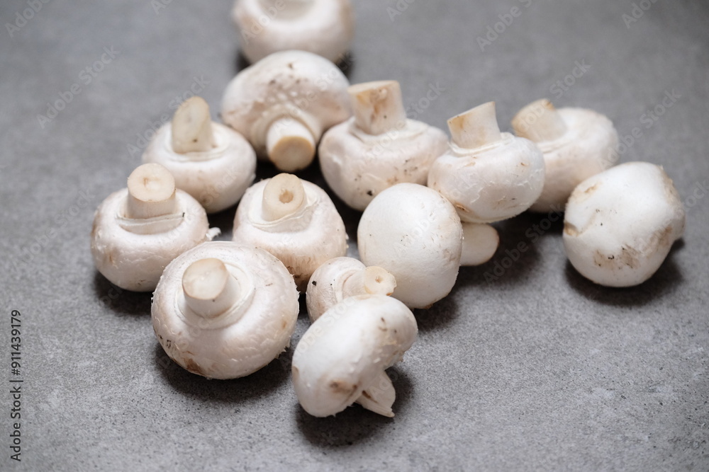 Raw mini mushroom champignon in a gray background. Top view Raw mini mushroom champignon in a gray background. Top view