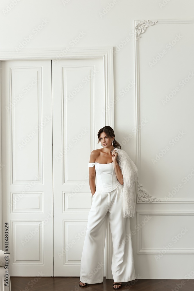 Beautiful brunette woman dressed in a sleek white suit poses gracefully in a bright, all-white photo studio. Stylish and professional image for business concepts Beautiful brunette woman dressed in a sleek white suit poses gracefully in a bright, all-white photo studio. Stylish and professional image for business concepts