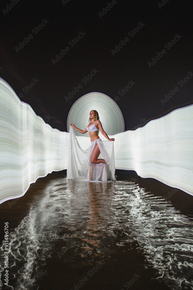 Young slim girl posing in water with abstract light effect