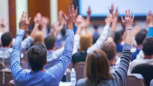 Backside perspective of attendees raising hands at a conference