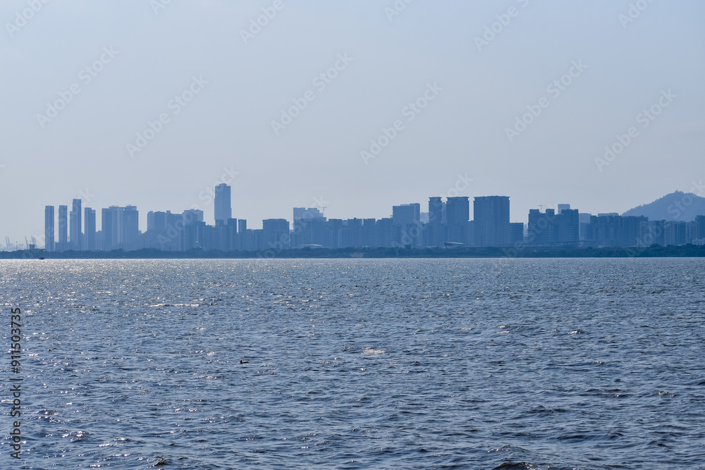 The view Cityscape of Shenzhen, Guangdong, China from the shore of Shenzhen Bay. City in the summer day. Modern city waterfront downtown skyline,China. Nature and landscape.