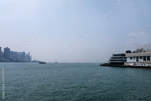 The view from Tsim Sha Tsui Victoria Harbour, Hong Kong. Iconic terminal and Hong Kong cityscape. Travel and nature scene.  photo