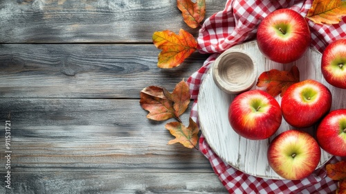 Autumn harvest of red apples on wooden table with checkered cloth