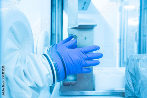 Close up scientist wearing blue gloves working in the flume hood for laboratory infection control test.Selective focus scientist hand holding chemotherapy drug at pharmacy unit.