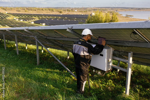Electric company employee checking technical condition solar panels