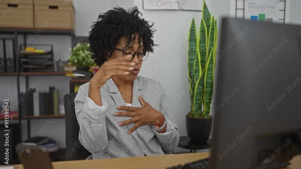 A young african american woman with curly hair, wearing glasses, conducts a video call in a modern office, gesturing expressively, surrounded by shelves and green plants. A young african american woman with curly hair, wearing glasses, conducts a video call in a modern office, gesturing expressively, surrounded by shelves and green plants.