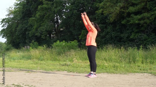 Woman makes exersices in the morning before jogging photo