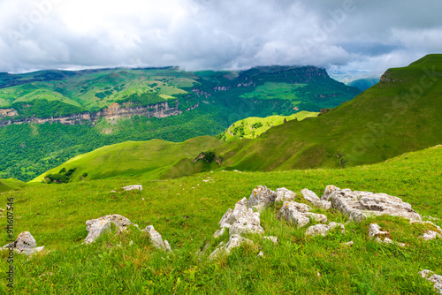 Picturesque rocks on a green canyon slope in a mountainous area in cloudy weather. Caucasus photo