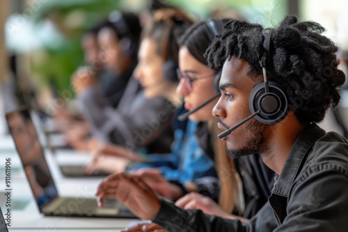 Multi-ethnic business people working in a call center in the office. Focus on African American black man wearing headset. photo