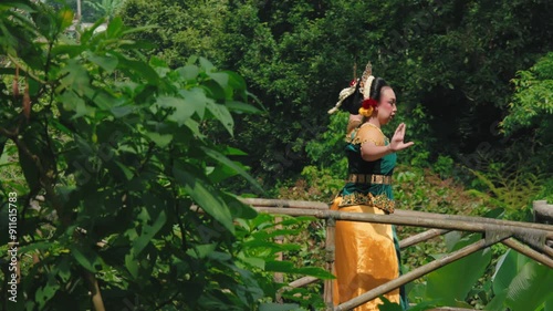 Traditional Dancer on Bamboo Bridge in Nature photo