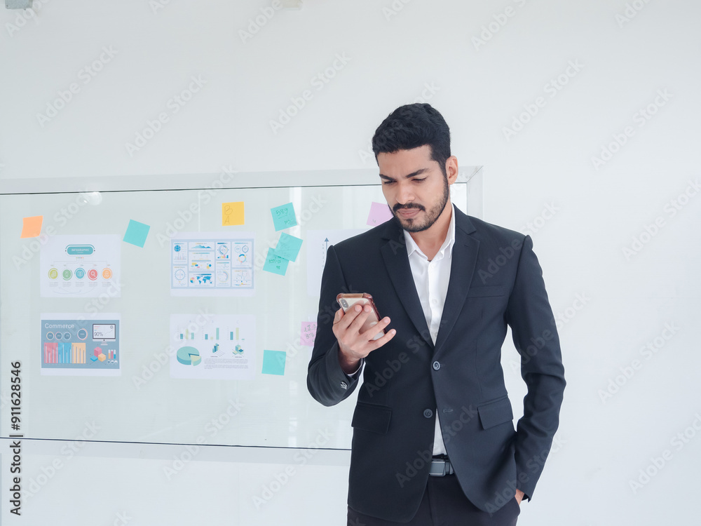 Business man portrait asian one person wearing a black suit handsome standing looking success committed hand holding mobile phone and laptop ready for work inside the office, with white background Business man portrait asian one person wearing a black suit handsome standing looking success committed hand holding mobile phone and laptop ready for work inside the office, with white background