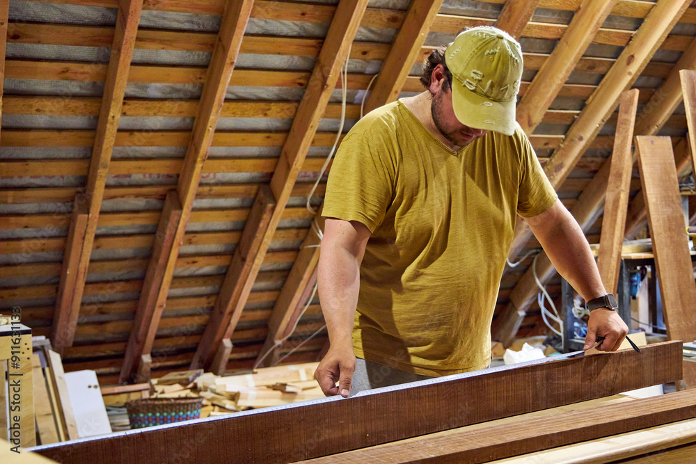 Fototapeta premium a man in a home carpentry shop selects boards for work