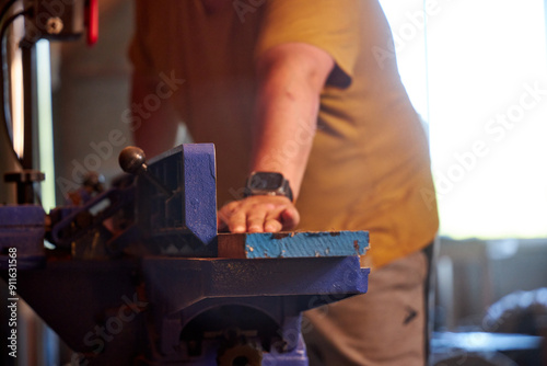 man sawing wood on a jointer in a home workshop photo