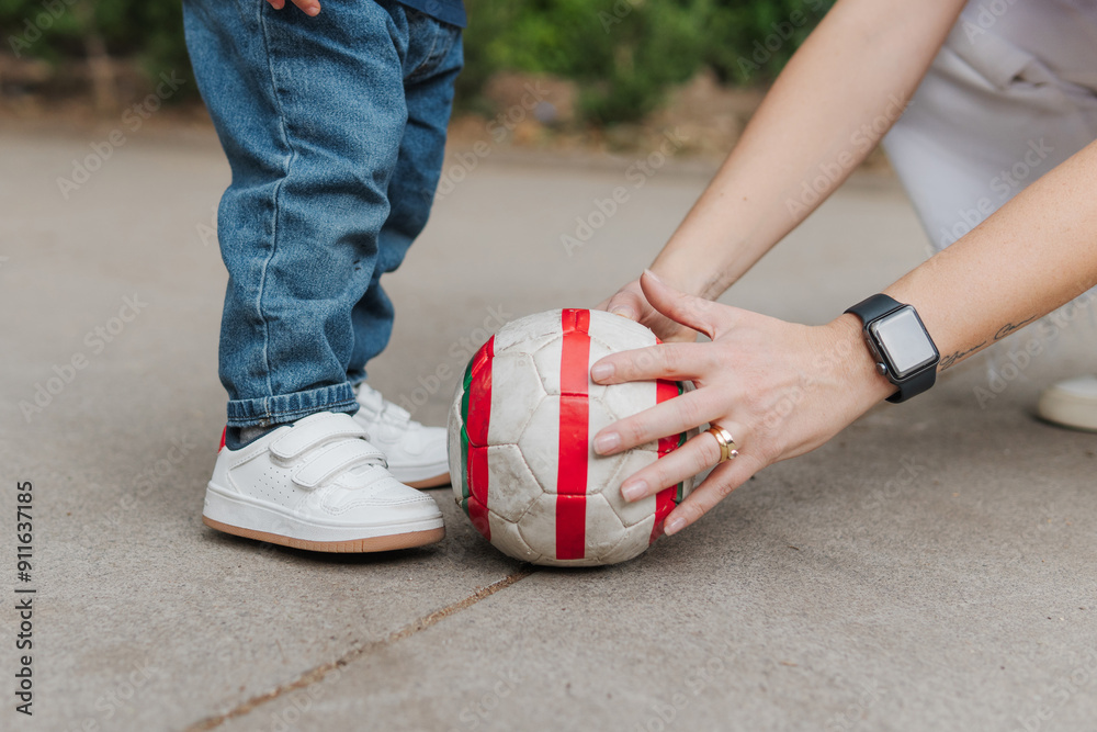 © Daniel Zapata/Stocksy - Mom and son playing soccer in the park.