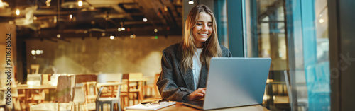 Stylish woman manager freelancer working on laptop while sitting in cozy cafe. High quality photo