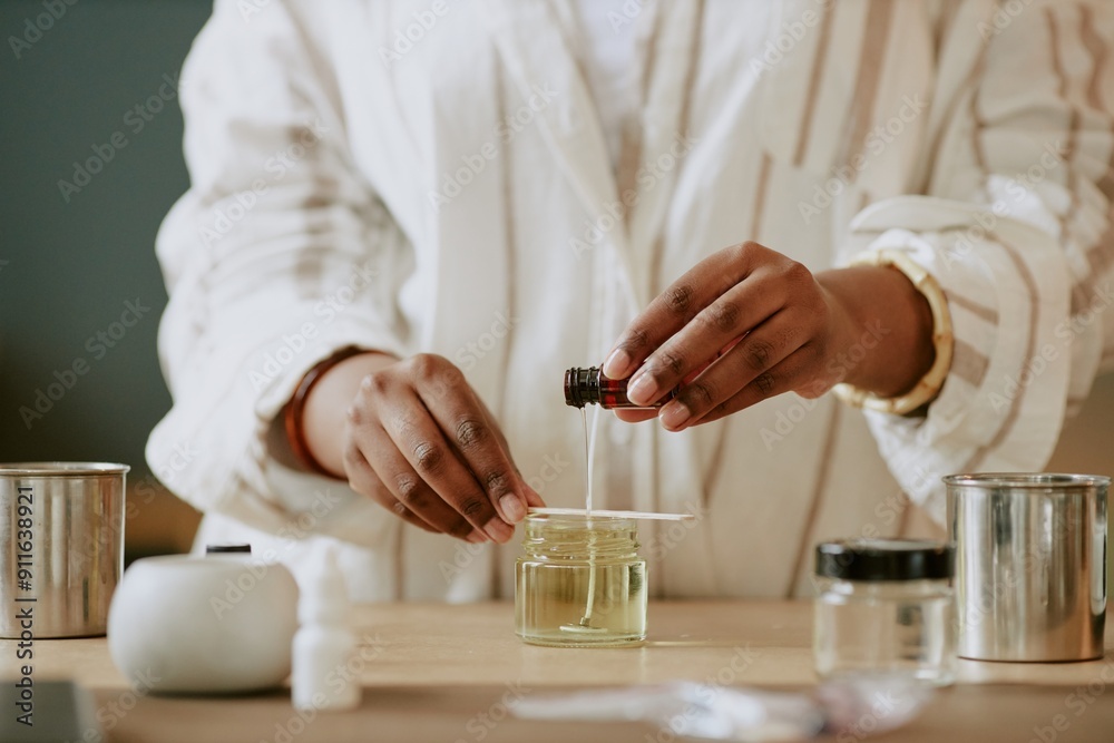Pair of hands blending essential oils for perfume making in an artisan lab with various containers. Scene captures precision and dedication of the craft without revealing identity Pair of hands blending essential oils for perfume making in an artisan lab with various containers. Scene captures precision and dedication of the craft without revealing identity