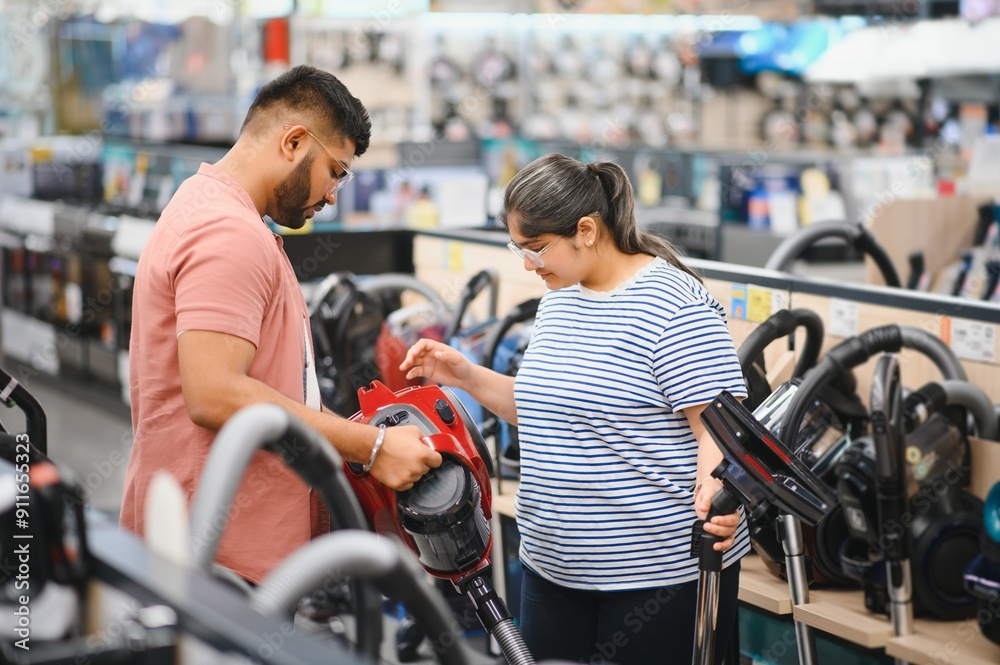 Young beautiful indian couple buying new vacuum cleaner at tech store