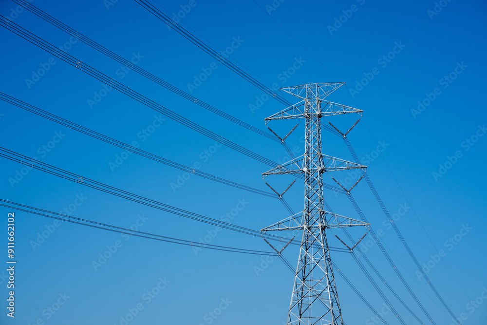Electric pole with wires against a blue sky, showing power lines in close up. Electric pole with wires against a blue sky, showing power lines in close up.