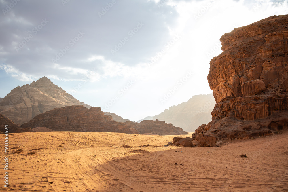 Fototapeta premium Jordanian Desert with Sandy Surface and Rocky Cliff in the Middle East. Beautiful Landscape of Wadi Rum in Jordan in the Afternoon. 