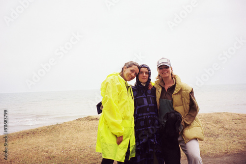 Women friends standing near ocean photo