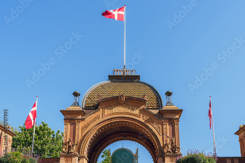 Entrance to Tivoli Park with Danish flags fluttering in the wind