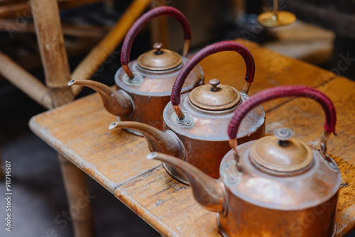 Vintage Copper Teapots on Wooden Table photo