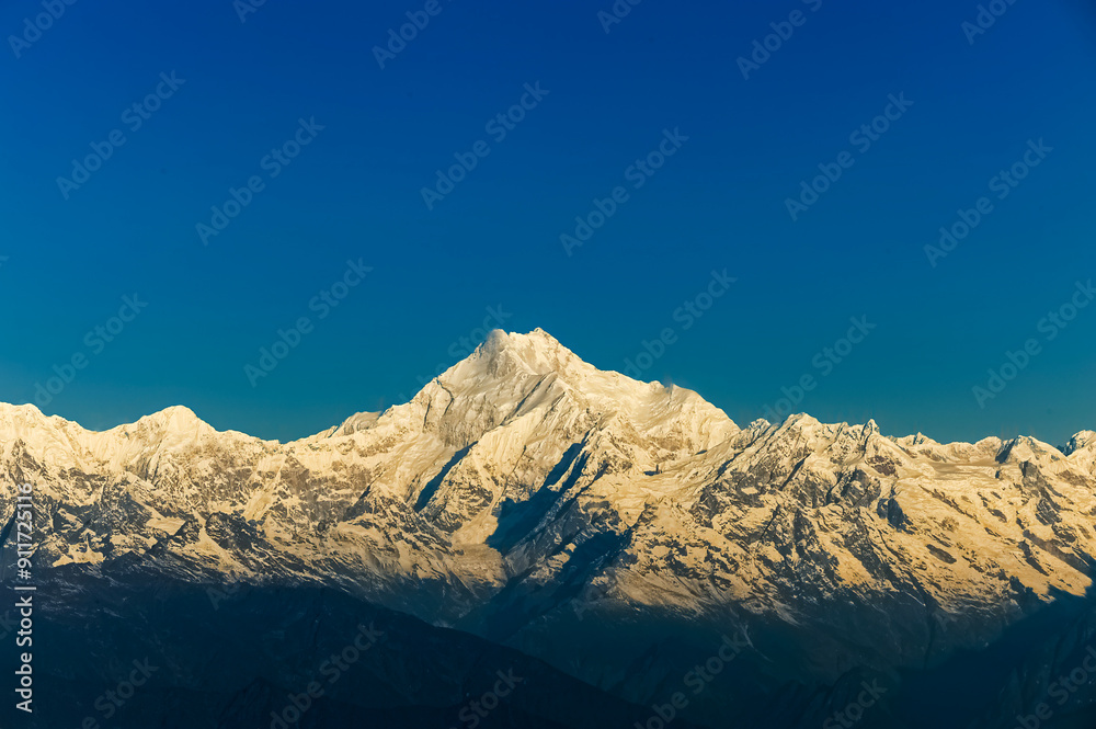 Beautiful first light from sunrise on Mount Kanchenjugha, Himalayan mountain range, Sikkim, India. Orange tint on the mountains at dawn Beautiful first light from sunrise on Mount Kanchenjugha, Himalayan mountain range, Sikkim, India. Orange tint on the mountains at dawn