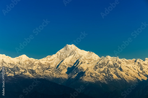 Beautiful first light from sunrise on Mount Kanchenjugha, Himalayan mountain range, Sikkim, India. Orange tint on the mountains at dawn