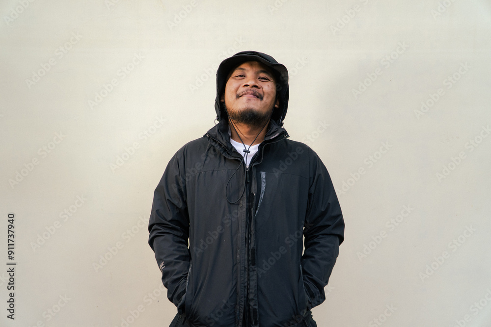 Portrait of Asian man wearing adventure clothes and doing various poses. Macho and smiling adult man wearing white shirt and jacket with hood isolated on beige background Portrait of Asian man wearing adventure clothes and doing various poses. Macho and smiling adult man wearing white shirt and jacket with hood isolated on beige background