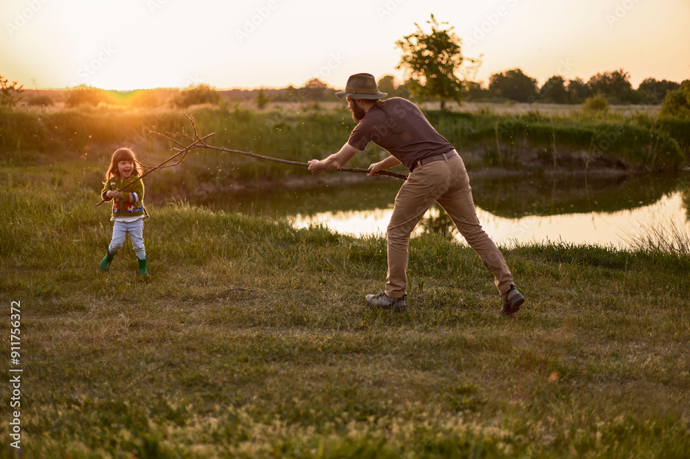young father playing with his little daughter at sunset young father playing with his little daughter at sunset