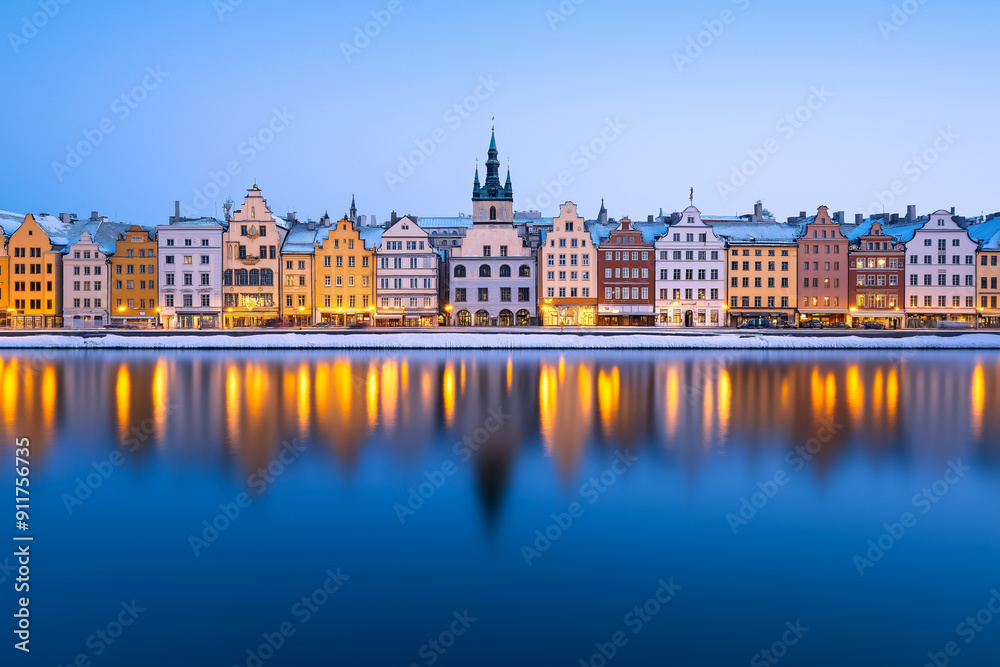Fototapeta premium Scenic winter evening view of colorful old town buildings reflecting in calm water in Stockholm, Sweden, perfect for Christmas cards