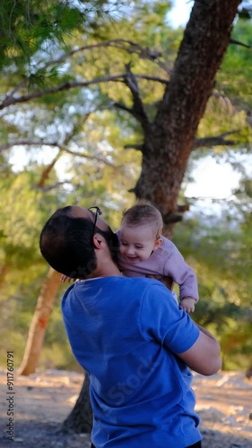 A father lifting his baby girl up to the sky, making her smile with joy and sharing a wonderful moment togethe