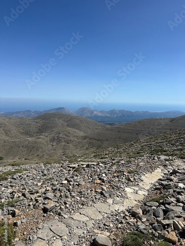 Beautiful panoramic view from Psiloritis (summit Ida), Mount Ida in Kouloukonas, Crete, Greece. Hiking in the sun, rocky terrain with clear blue sky. photo