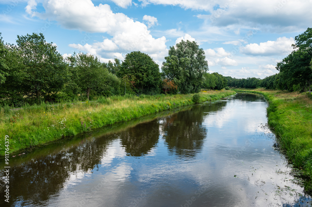 Green trees reflecting in the River Hase, Herzlake, Lower Saxony, Germany Green trees reflecting in the River Hase, Herzlake, Lower Saxony, Germany