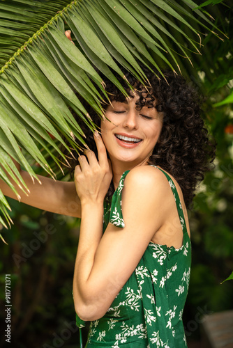 Exotic female model among green leaves